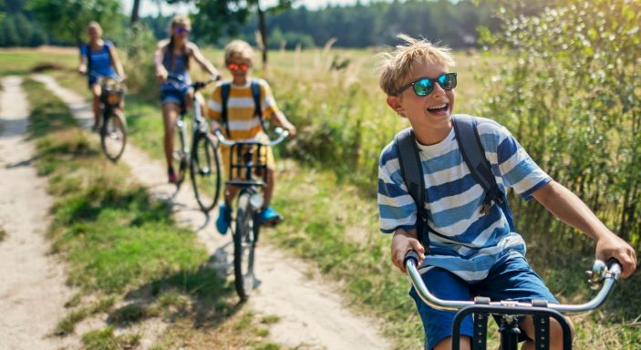 4 people cycling through a field