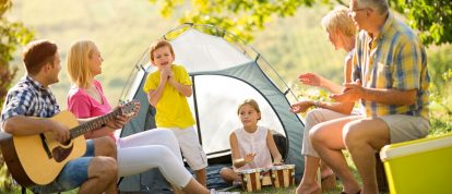 Famille heureuse riant à l'extérieur d'une tente