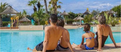 Famille assise au bord du Yelloh! Village piscine en france