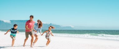 Happy family running on a beach