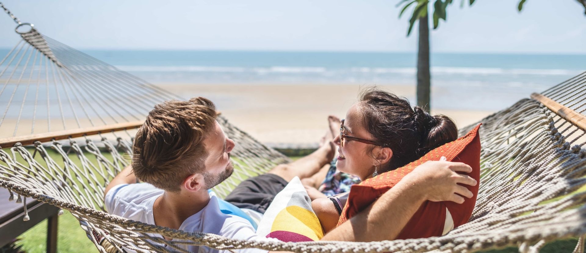 Couple se relaxant sur la plage en toute tranquilité grâce à leur assurance annulation camping