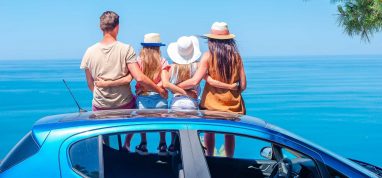 Family sat on a hire car on holiday - car rental with Campsited
