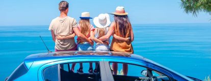 Family sat on a hire car on holiday - car rental with Campsited