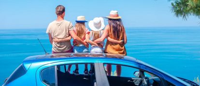 Family sat on a hire car on holiday - car rental with Campsited
