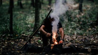 Un homme fait un feu de camp