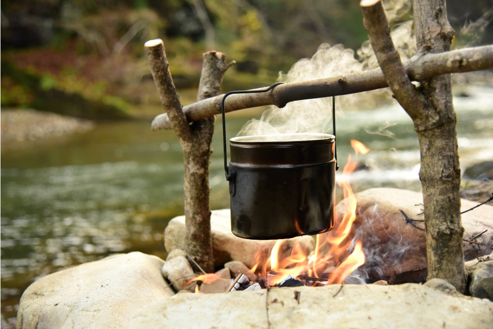 Cooking food in pot over campfire outdoor