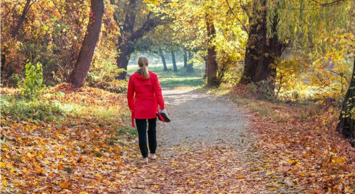 Une femme marche pieds nus dans la forêt en automne