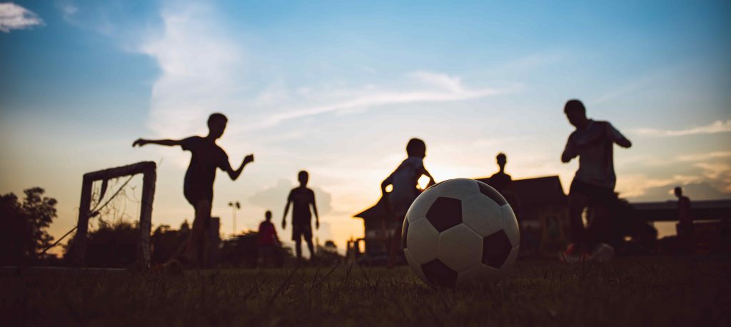 Des enfants jouent au foot dans un camping