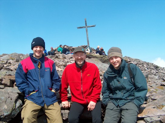 Three men at the summit of a mountain in Kerry