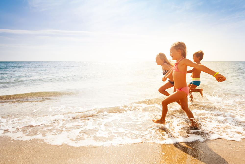 Kids paddling on a sandy beach - Des enfants pagayant sur une plage de sable-