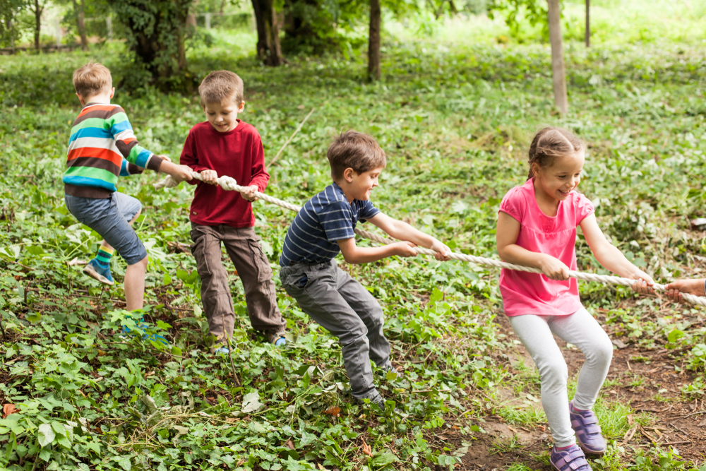 Enfants jouant au tir à la corde dans un camping avec animations