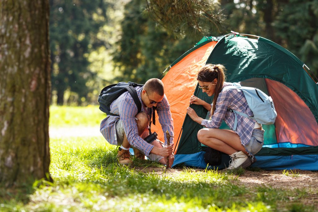 Couple setting up a tent | Couple en train de monter une tente