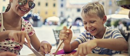 Family enjoying pizza on a piazza in Italy