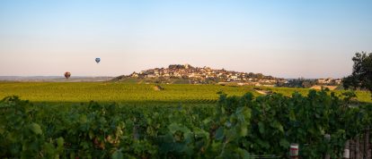 Panorama sur le vignoble et le village de Sancerre, et deux montgolfières dans le ciel, campings dans le Cher