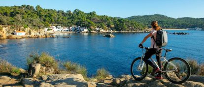 Femme faisant du vélo le long de la mer Méditerranée. Campings dans la Costa Brava, Espagne