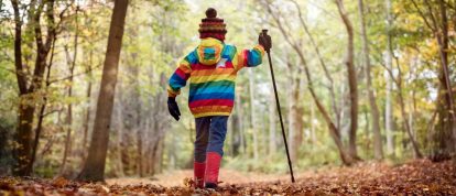 Un bambino che cammina tra le foglie autunnali mentre è in campeggio in agosto in Francia, Offerte di Novembre per le tue Vacanze in Campeggio