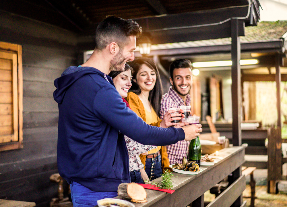 Des amis prennent un verre sur la terrasse d'un mobile home. |Friends having drinks on the terrace of a mobile home. |