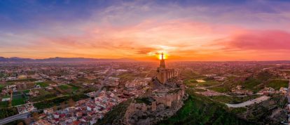 Panoramisch uitzicht op de middeleeuwse ruïne van het kasteel van Monteagudo, twaalf rechthoekige torens die de heuvel omcirkelen en het standbeeld van Jezus Christus op de top, bij Murcia, Spanje - Campings in Murcia