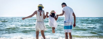Familie speelt in de golven en geniet van de camping vakantie aanbiedingen