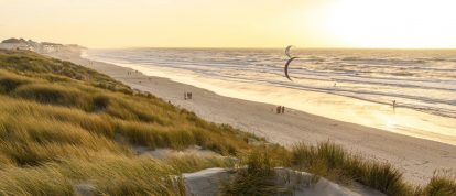 Uitzicht op Fort-Mahon-Plage met wandelaars en kitesurfers, campings in de Somme, Frankrijk