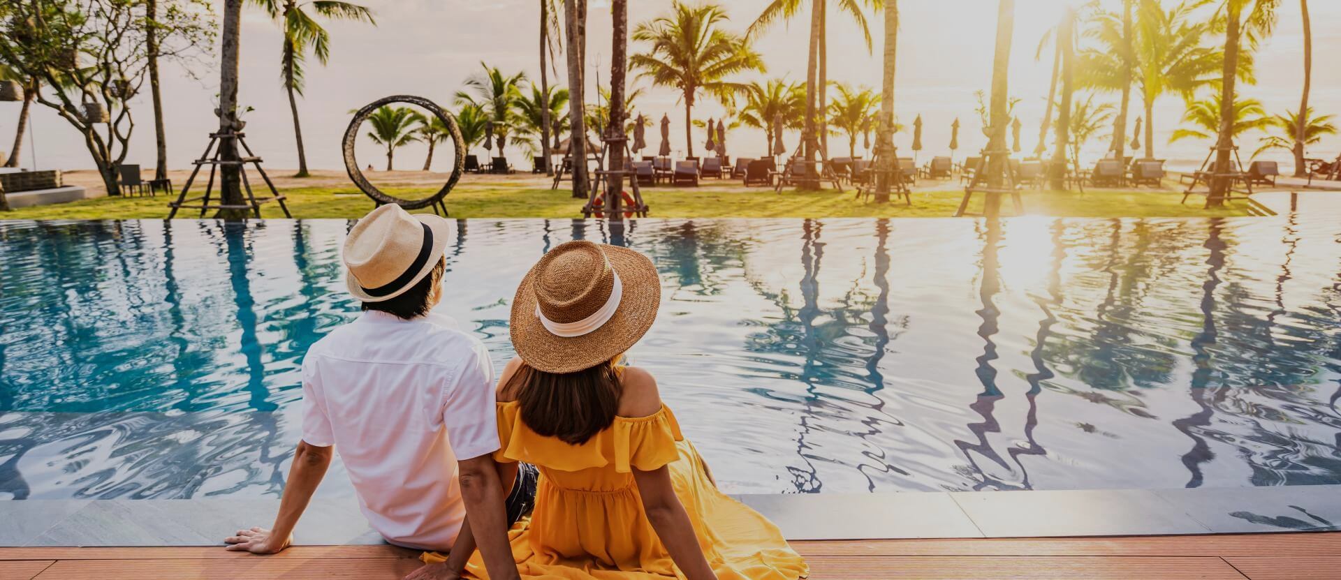 Young couple relaxing and enjoying the sunset by a pool at at luxury campsite in France