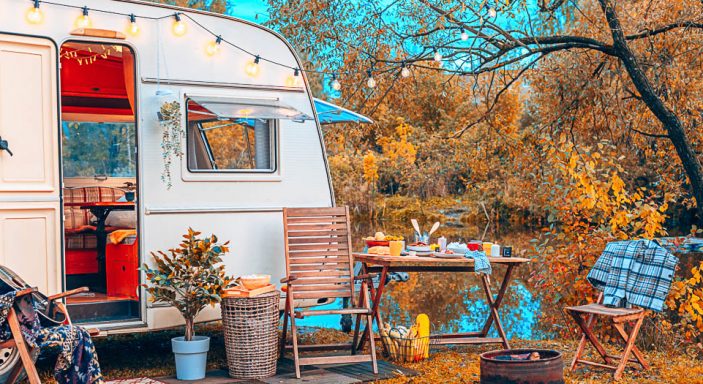 caravan aperto con tavola imbandita in campeggio in autunno