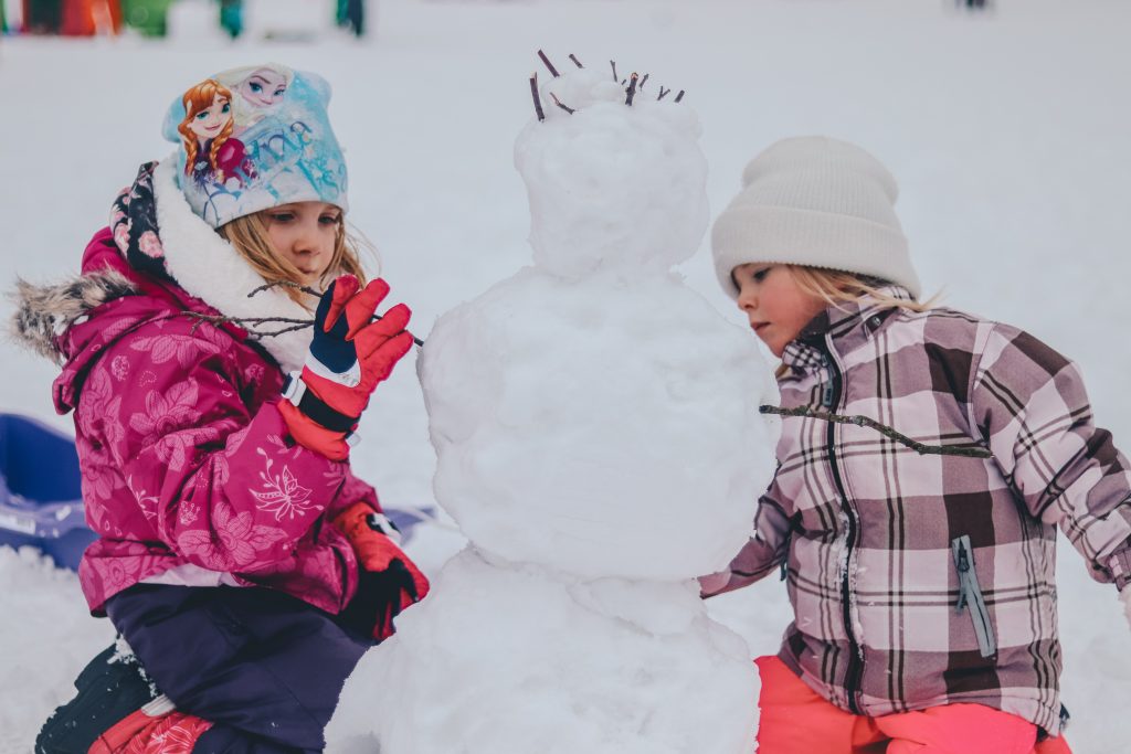 enfants créent un bonhomme de neige