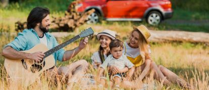 Il padre accorda la chitarra durante un picnic in famiglia a base di delizie dell'Ardèche centrale - campeggi a Privas