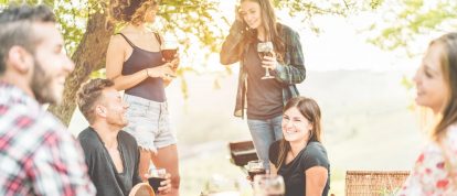 Gelukkige vrienden genieten van een picknick buiten in de natuur met wijn - campings in Châteauroux