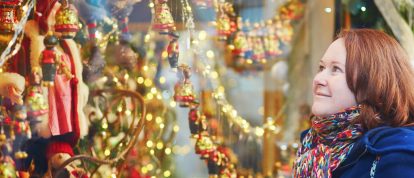 Vrouw bewondert een kraam op de kerstmarkt in Straatsburg - campings in Straatsburg