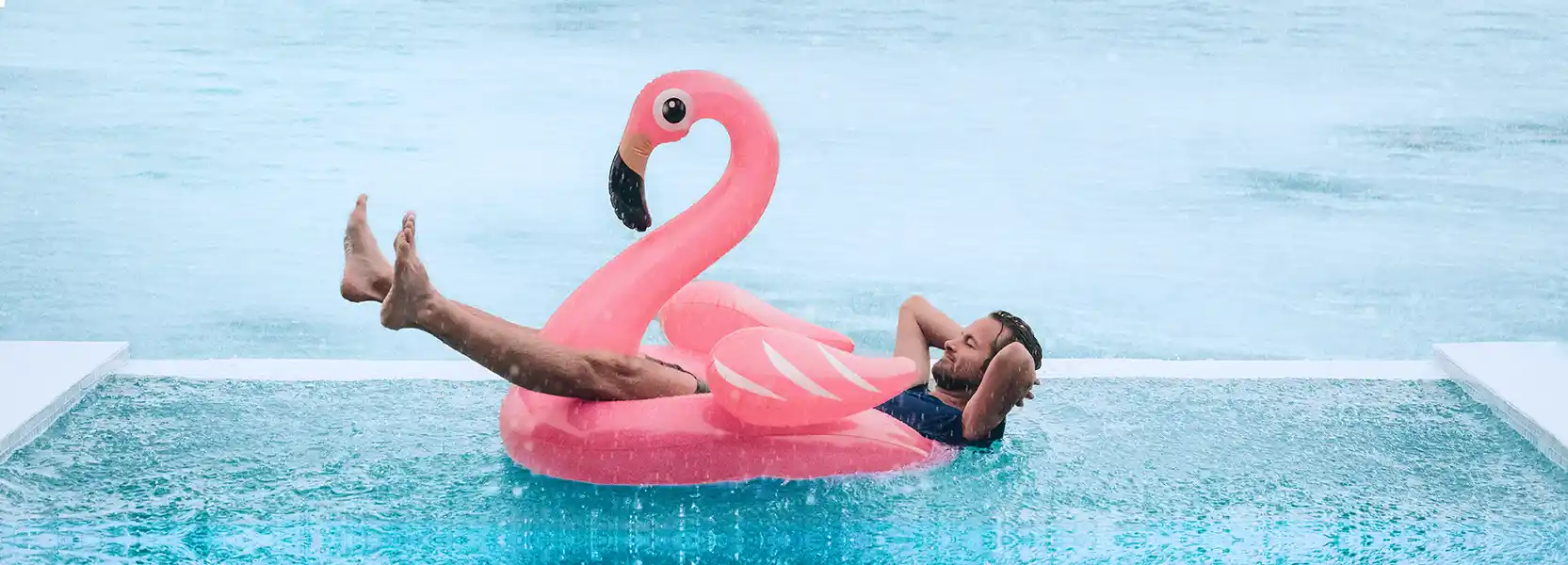 Man relaxing in a pool while it's rainingCampsited Weather Guarantee Holiday Insurance