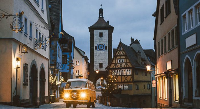 Orangener Volkswagen T2, im Hintergrund Rothenburg ob der Tauber, Bayern, Deutschland, mit weihnachtlicher Beleuchtung