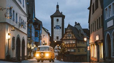 Orange Volkswagen Transporter T2 on background of Rothenburg ob der Tauber, Christmas decorated city of Franconia, Bavaria