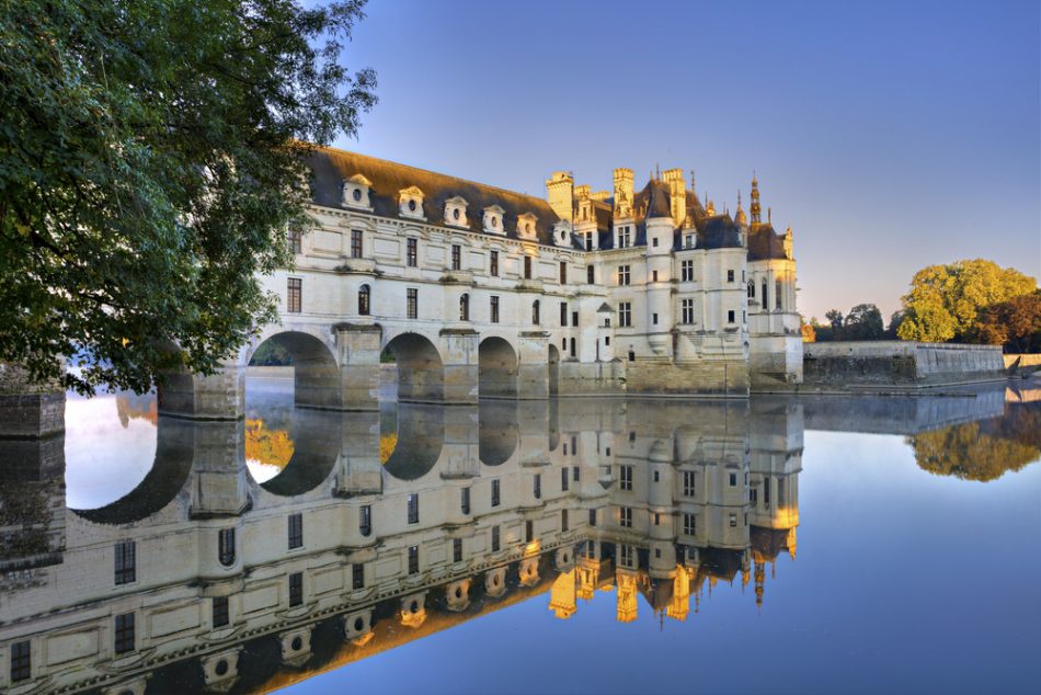 Das Schloss Chenonceau spiegelt sich im Wasser beim Sonnenuntergang, Loiretal, Frankreich