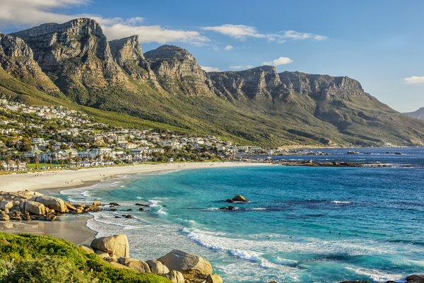 spiaggia sabbiosa con onde e grandi montagne