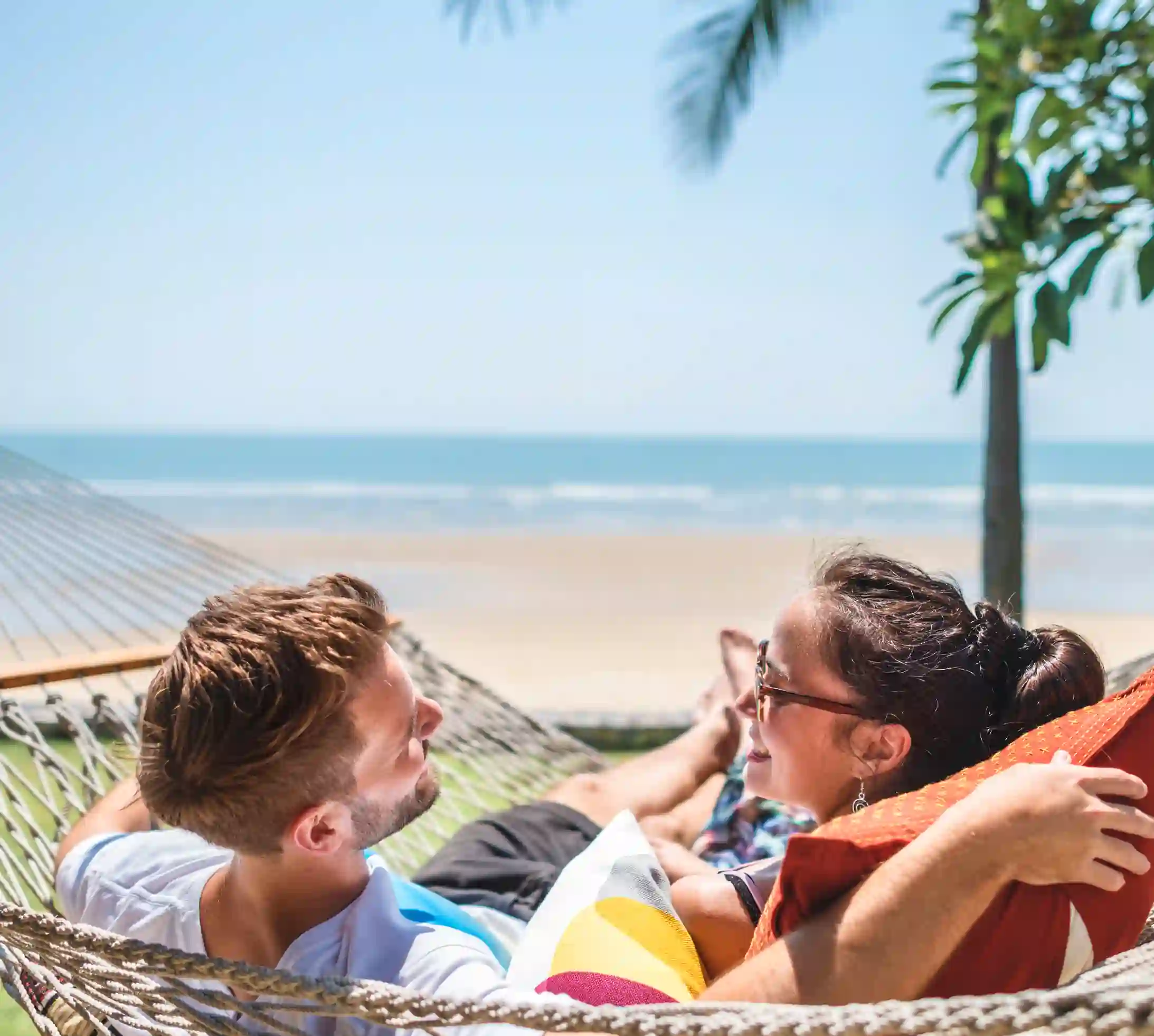 Couple relaxing on the beach in peace thanks to their camping cancellation insurance