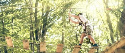 Ragazzo su un percorso di avventura nella foresta - Campeggi a Mont de Marsan