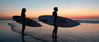 Family surfing in South Africa on the beach - winter sun holidays