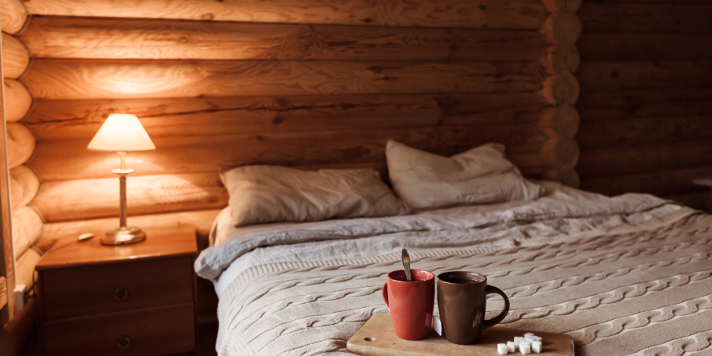 Double bed inside a wooden cabin. 2 hot chocolates