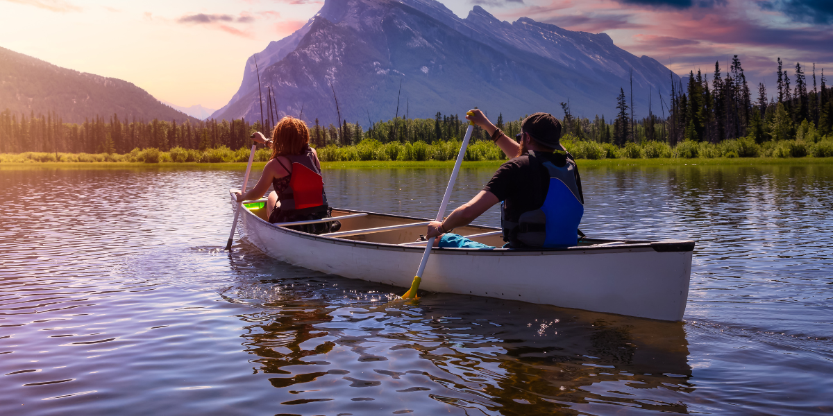 Couple faisant du canoe sur un lac avec une montagne en arriere-plan