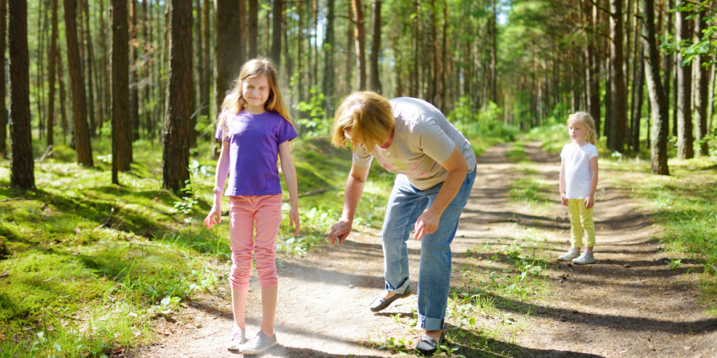 Homemade bug spray - Mother using bug repellent on daughter in the forest 