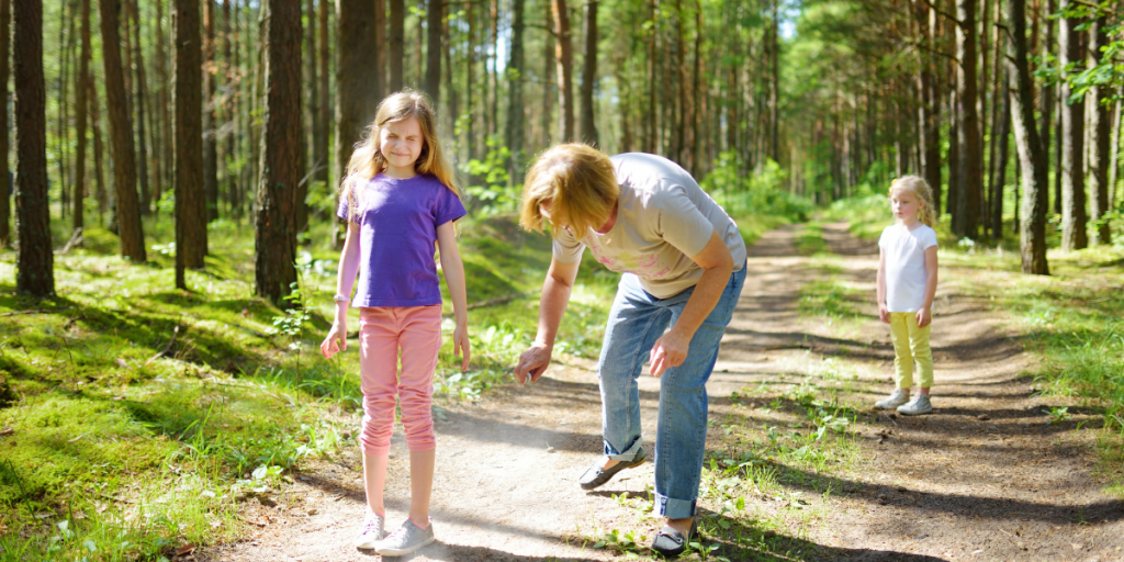 Homemade bug spray - Mother using bug repellent on daughter in the forest
