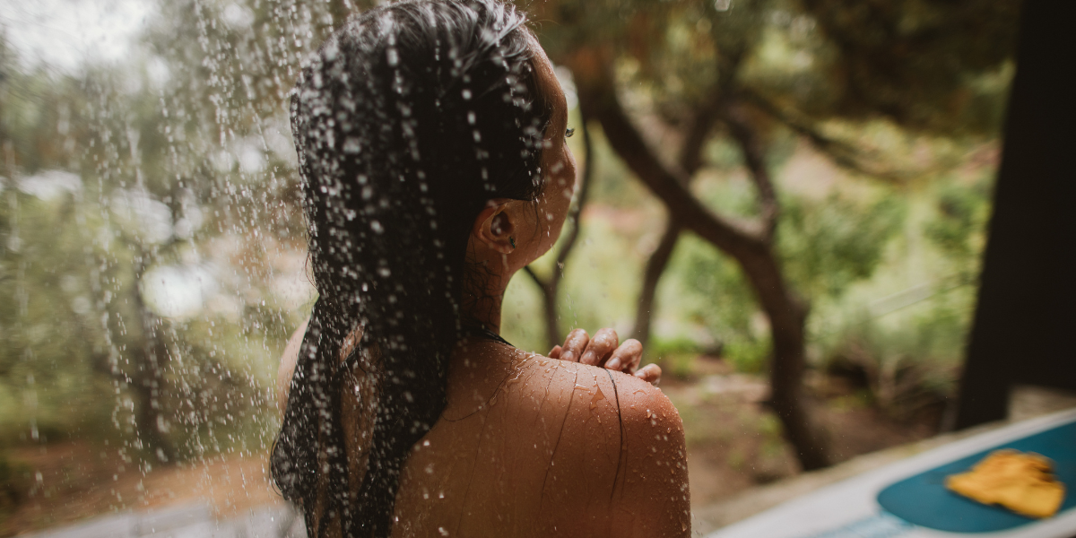 Frau unter Dusche in der Natur.