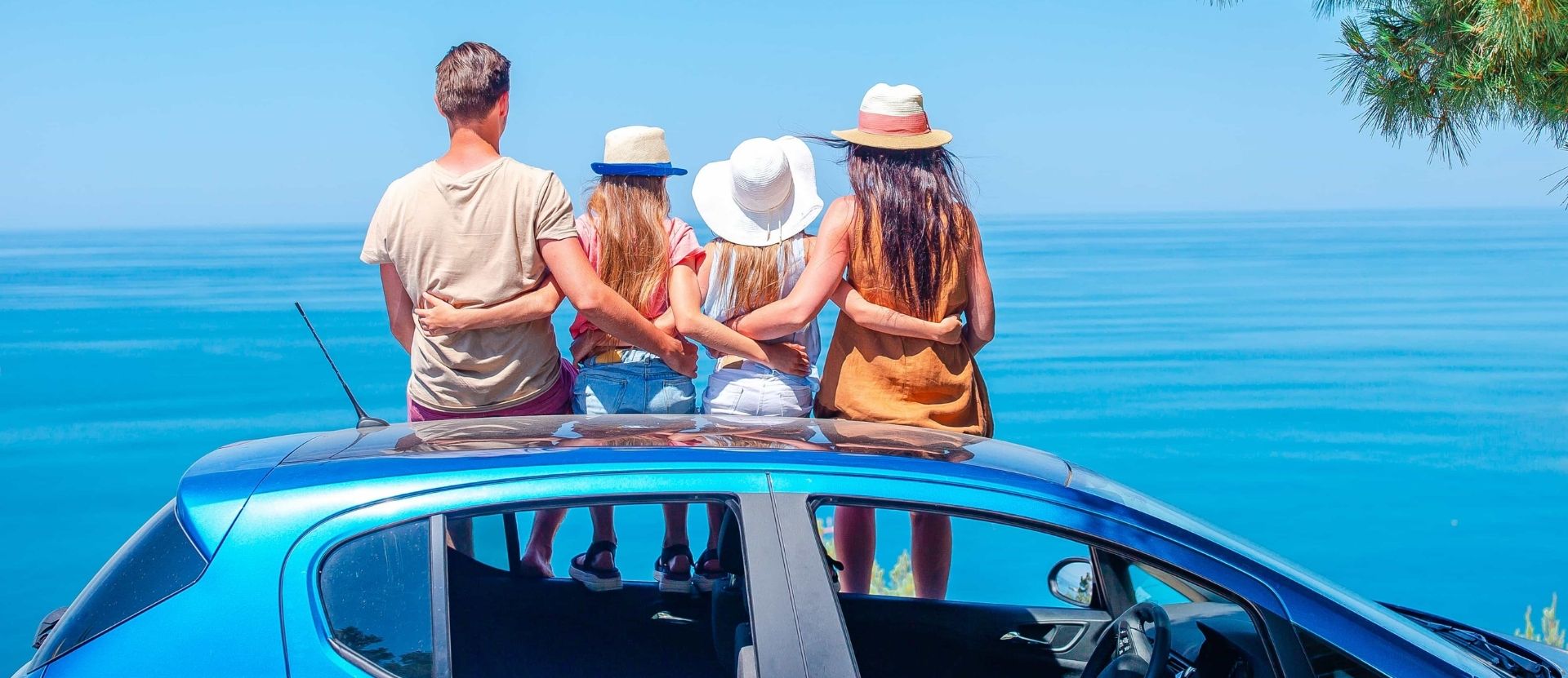 La familia sentada en un coche de alquiler en vacaciones - alquiler de coches con Campsited