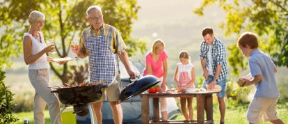 Una famiglia di tre generazioni che si gode un barbecue all'aperto in una splendida location