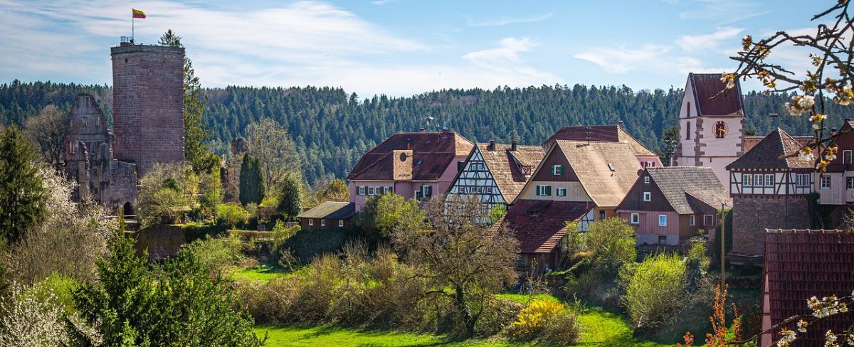 Grüne Landschaft im Schwarzwald, Deutschland mit Fachwerkhäusern und Burg im Hintergrund