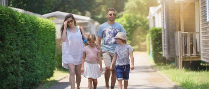 Eine glückliche Familie, die gemeinsam durch einen Campingplatz in Frankreich spaziert - Campingplätze in Valloire-sur-Cisse
